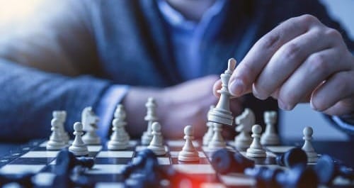 depth of field photography of man playing chess